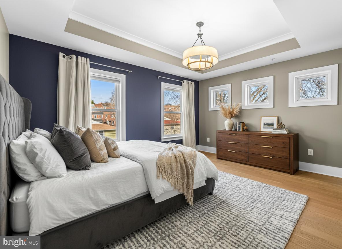 1456 Redfern Avenue Baltimore, MD 21211 - Photo 25 of 44 a spacious bedroom with a bed and a chandelier