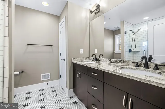 a bathroom with a granite countertop sink mirror and double