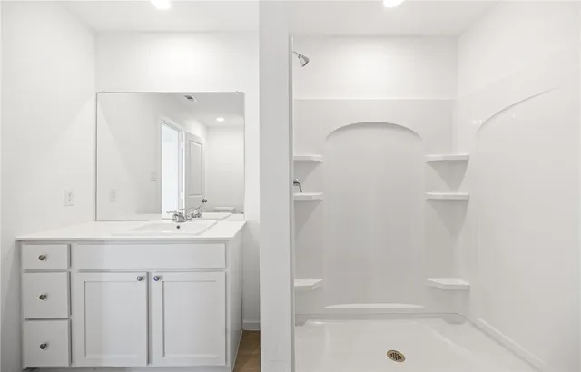 a bathroom with a shower sink and mirror