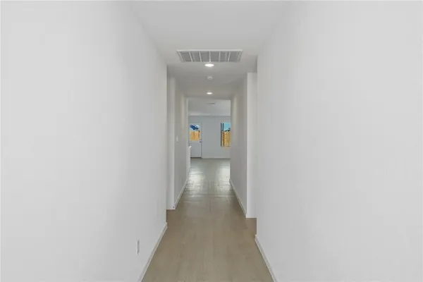 a view of a hallway with wooden floor