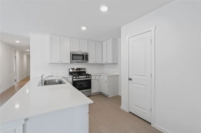 a kitchen with white cabinets and stainless steel appliances
