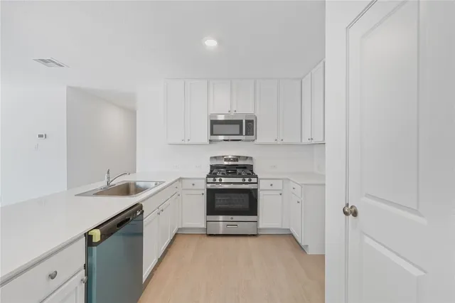 a kitchen with sink a stove and cabinets