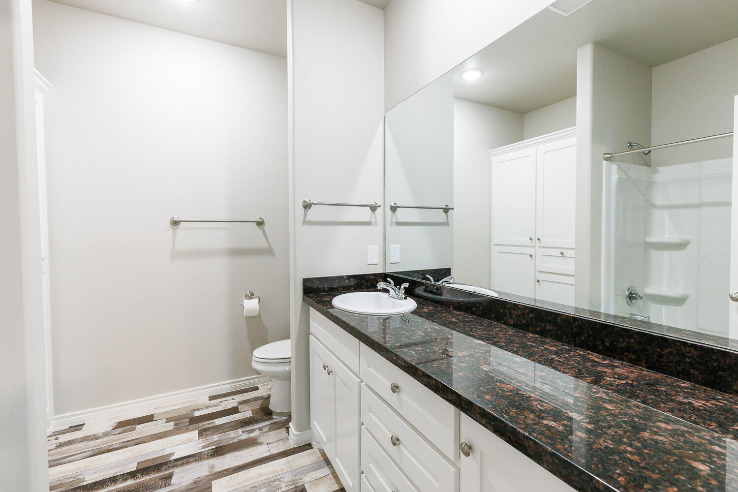 6956 12th Street Lubbock, TX 79416 - Photo 25 of 43 a bathroom with a granite countertop sink and a mirror
