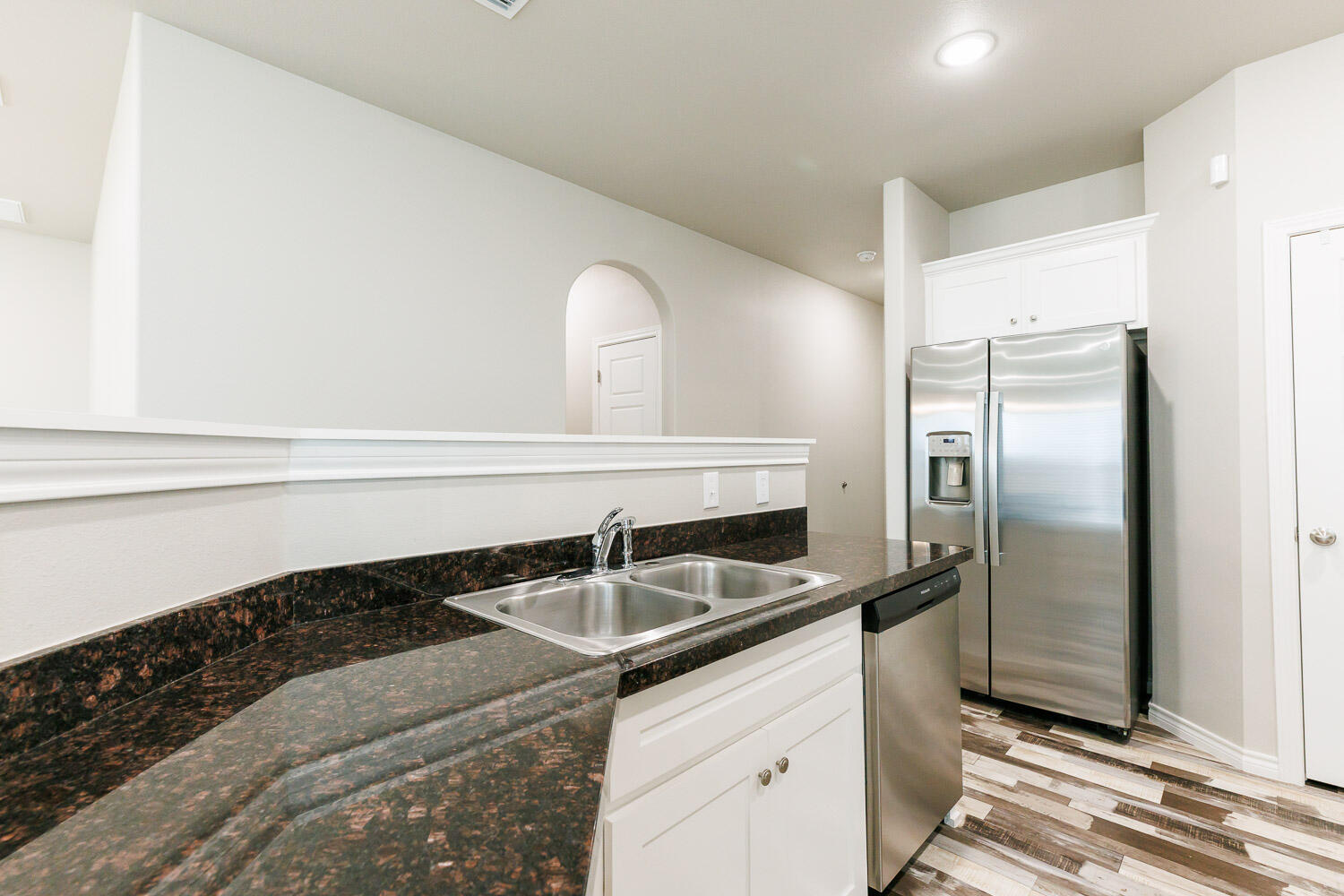 6956 12th Street Lubbock, TX 79416 - Photo 9 of 43 a kitchen with a sink and refrigerator
