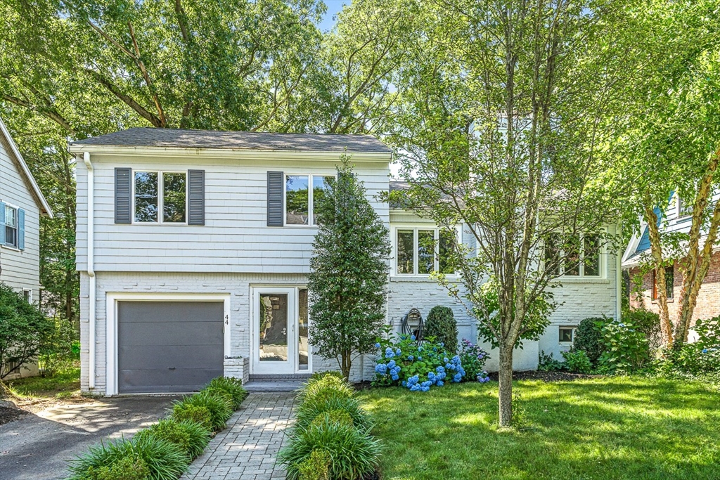 a front view of a house with a yard and trees