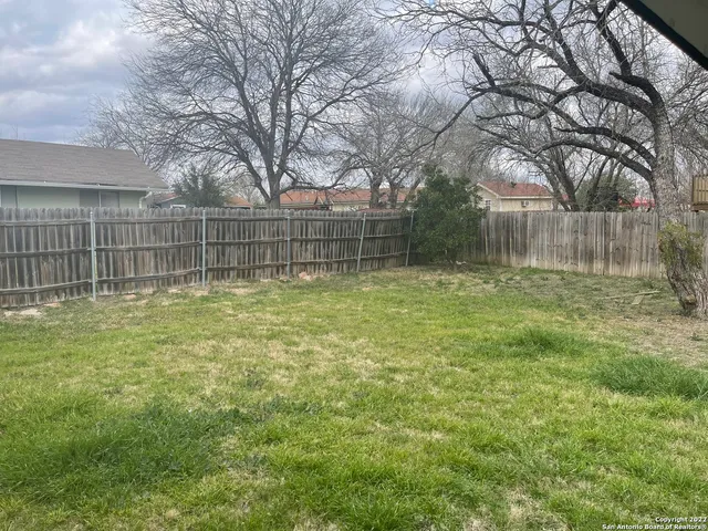 a backyard of a house with lots of green space and fountain