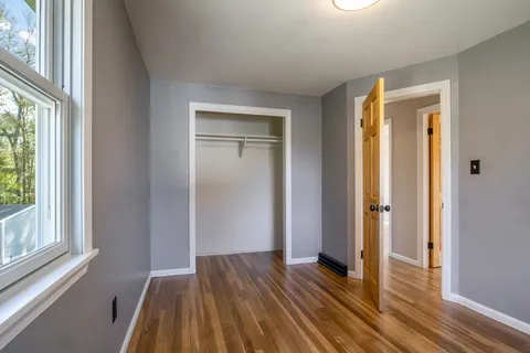 a view of a room with wooden floor and a window