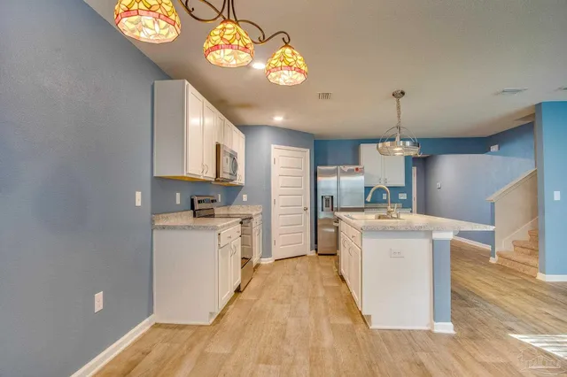 a kitchen that has a lot of cabinets and refrigerator