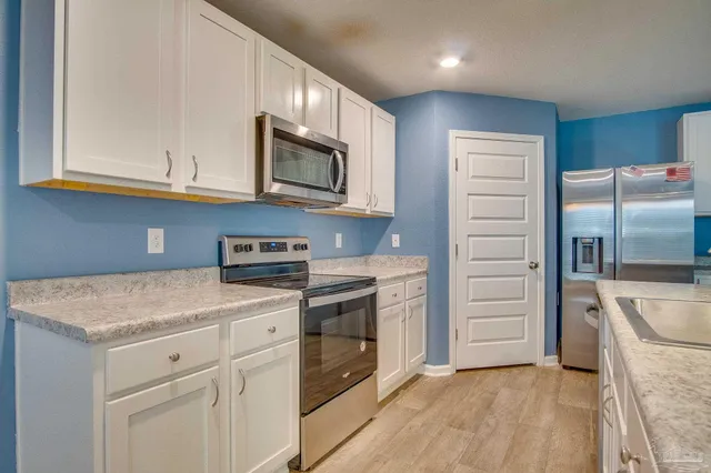 a kitchen with stainless steel appliances granite countertop a refrigerator and a stove top oven