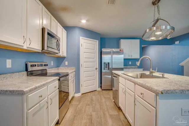 a kitchen with a sink dishwasher a stove and a refrigerator