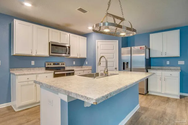 a kitchen with stainless steel appliances granite countertop a sink refrigerator stove and microwave
