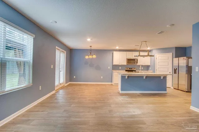 a large kitchen with stainless steel appliances kitchen island granite countertop a refrigerator and a stove top oven