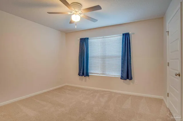 an empty room with a window and a fan