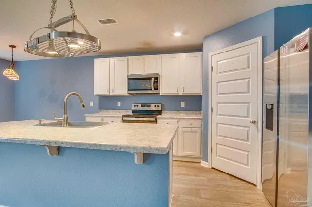 a kitchen with stainless steel appliances a refrigerator sink and cabinets