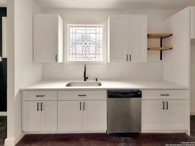 a kitchen with a sink cabinets and window