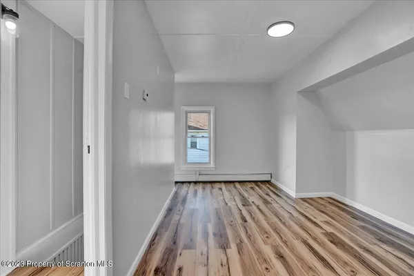 a view of room with window and wooden floor