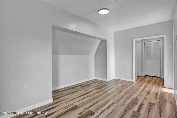 a view of an empty room with wooden floor