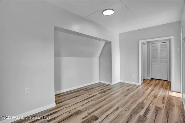 a view of an empty room with wooden floor