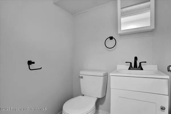 a bathroom with a toilet sink vanity and mirror