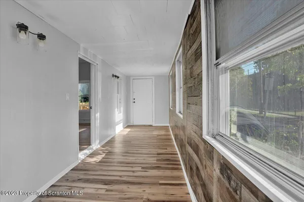 a view of a hallway with wooden floor and staircase