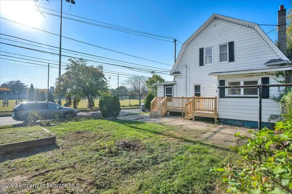 a view of a house with backyard and sitting area