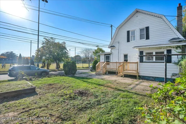 a view of a house with backyard and sitting area