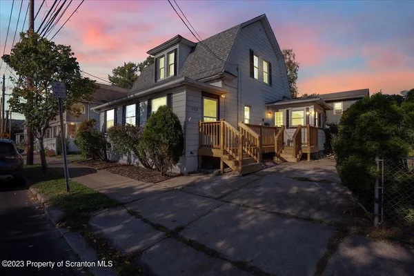 a view of a brick house with many windows next to a yard