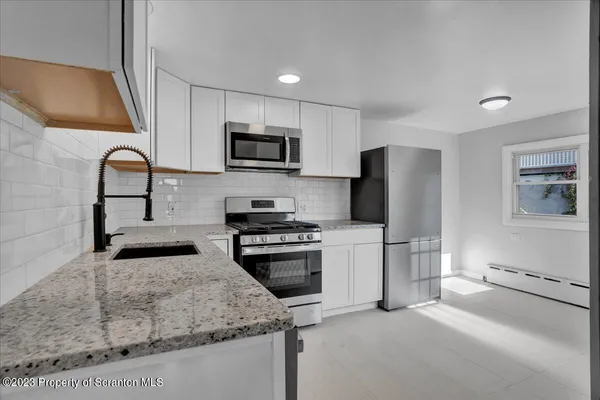 a kitchen with stainless steel appliances and a stove top oven