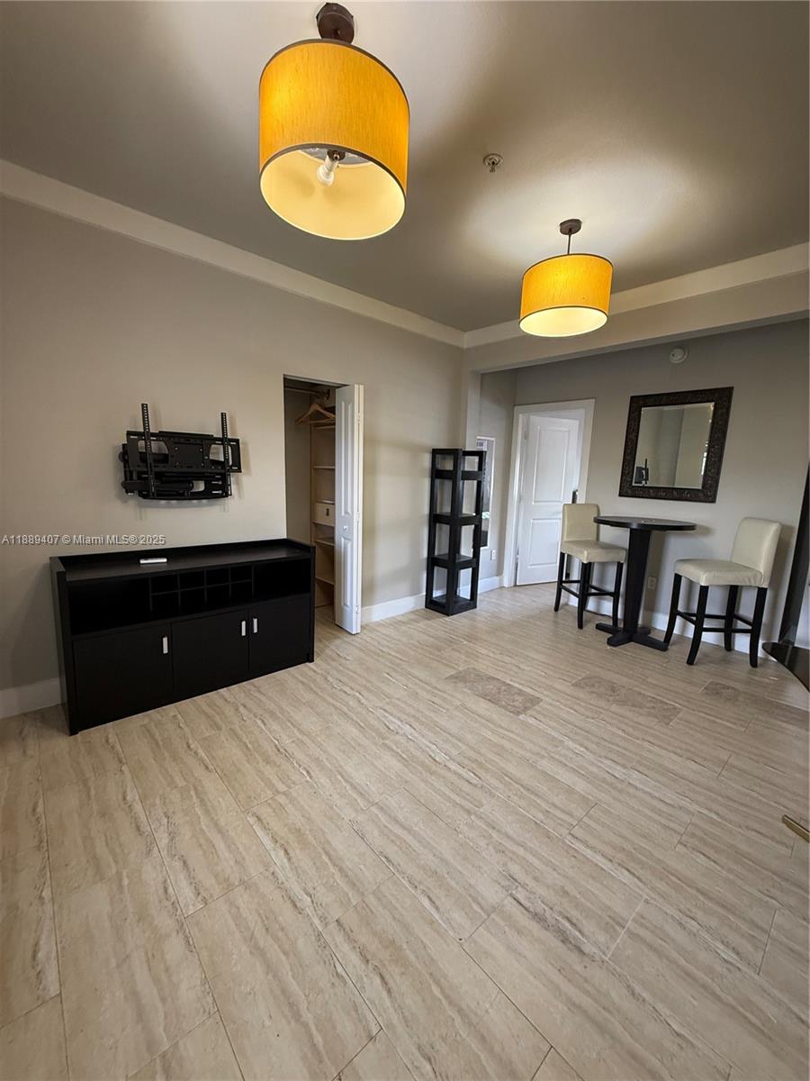 1330 Pennsylvania Avenue, Unit 313 Miami Beach, FL 33139 - Photo 10 of 14 a bedroom with a bed and a chandelier