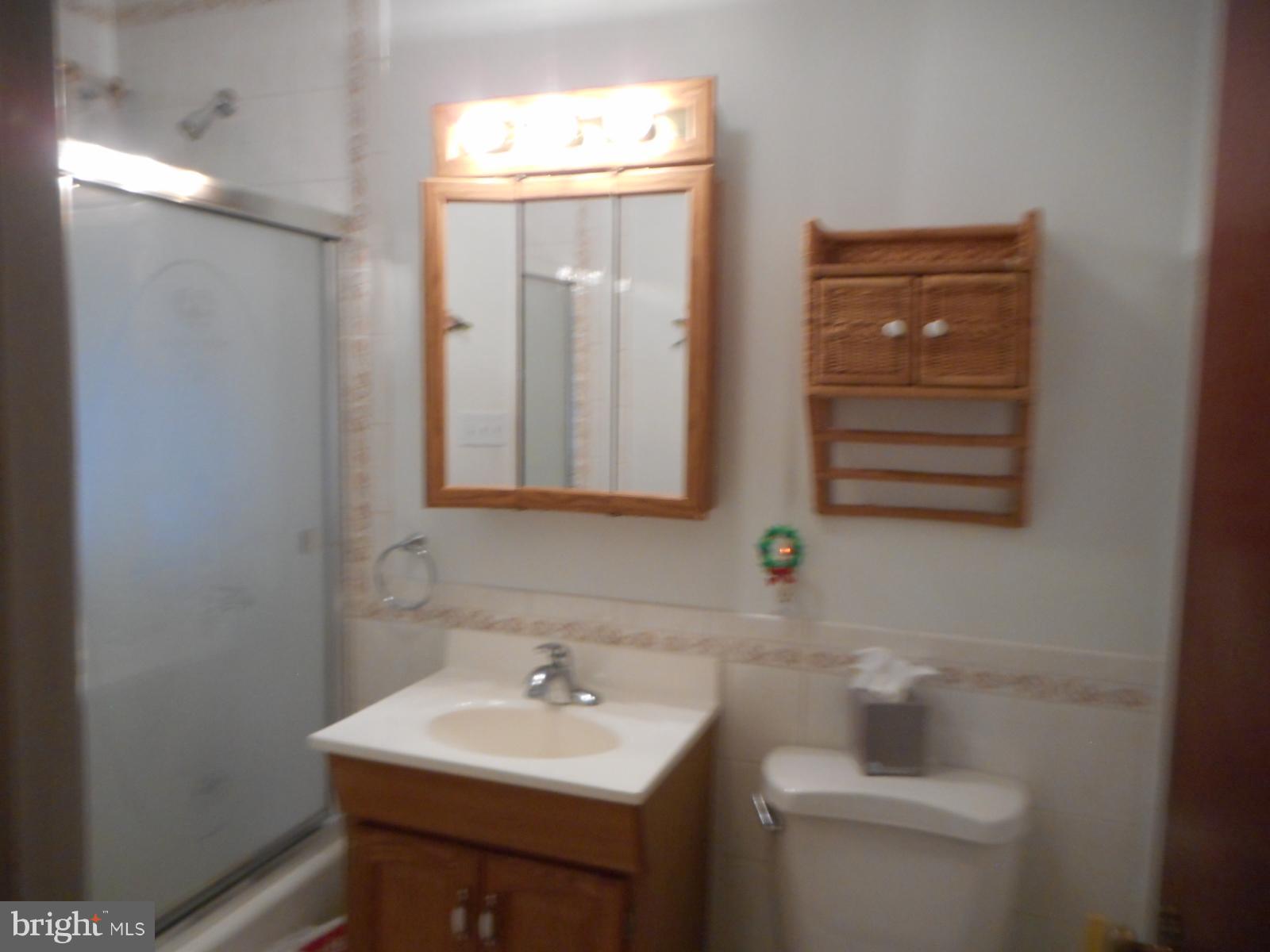 6501 Windsor Mill Road Baltimore, MD 21207 - Photo 12 of 17 a bathroom with a sink a toilet and mirror