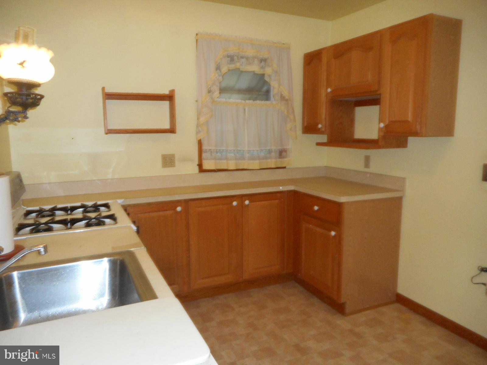 6501 Windsor Mill Road Baltimore, MD 21207 - Photo 7 of 17 a kitchen with stainless steel appliances a stove a sink and a microwave