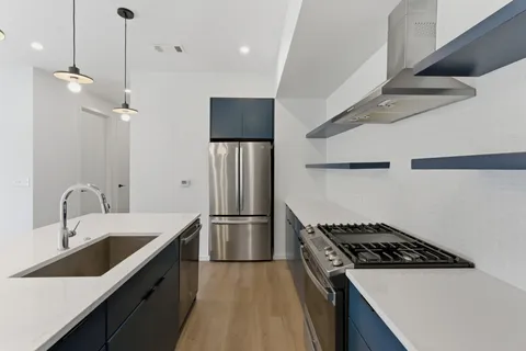 a kitchen that has a sink stainless steel appliances a counter space and a window