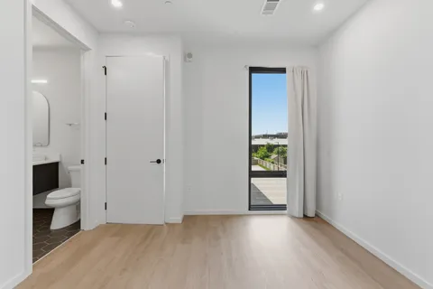 a view of a bathroom with a toilet and a hardwood