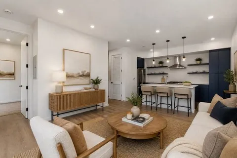 a living room with furniture kitchen and a table