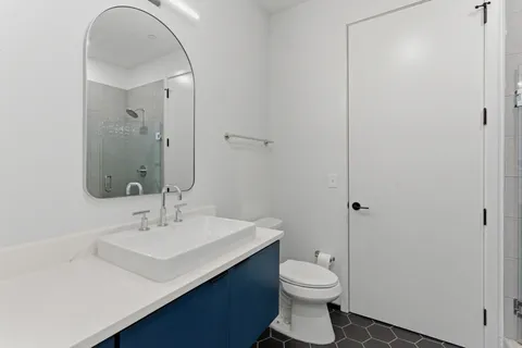a bathroom with a sink a toilet and shower