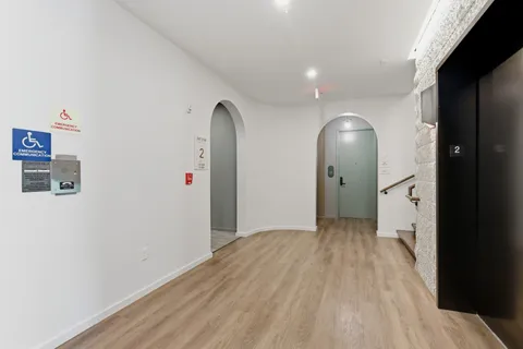 an empty room with wooden floor and mirror