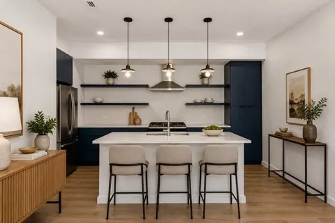 a kitchen with stainless steel appliances granite countertop a table chairs stove and refrigerator