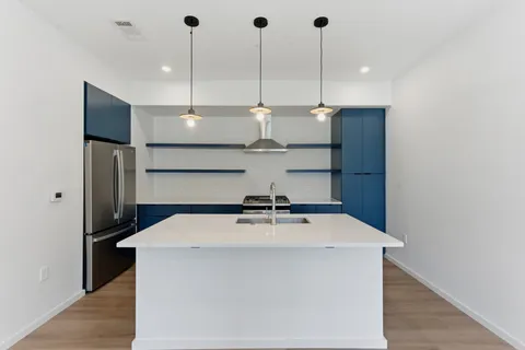 a kitchen with stainless steel appliances a table a fireplace and cabinets