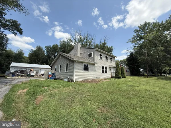 a front view of house with yard and trees in the background