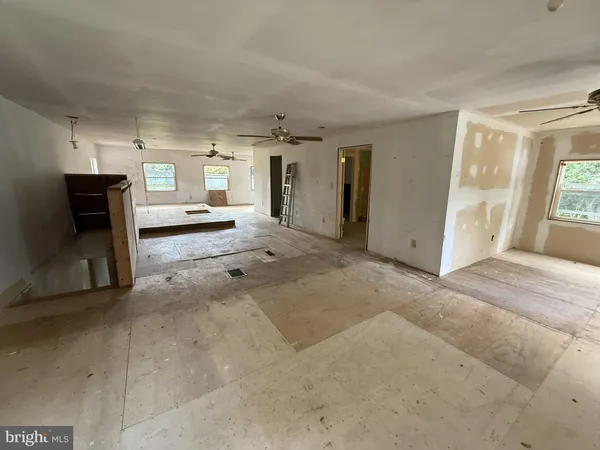 a view of a room with wooden floor and windows