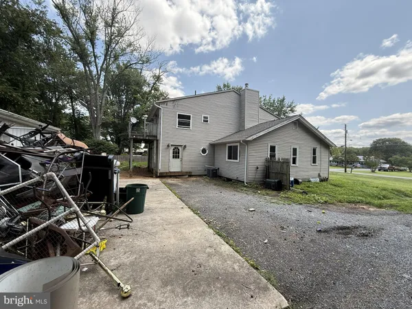 a view of a house with a yard and a large tree