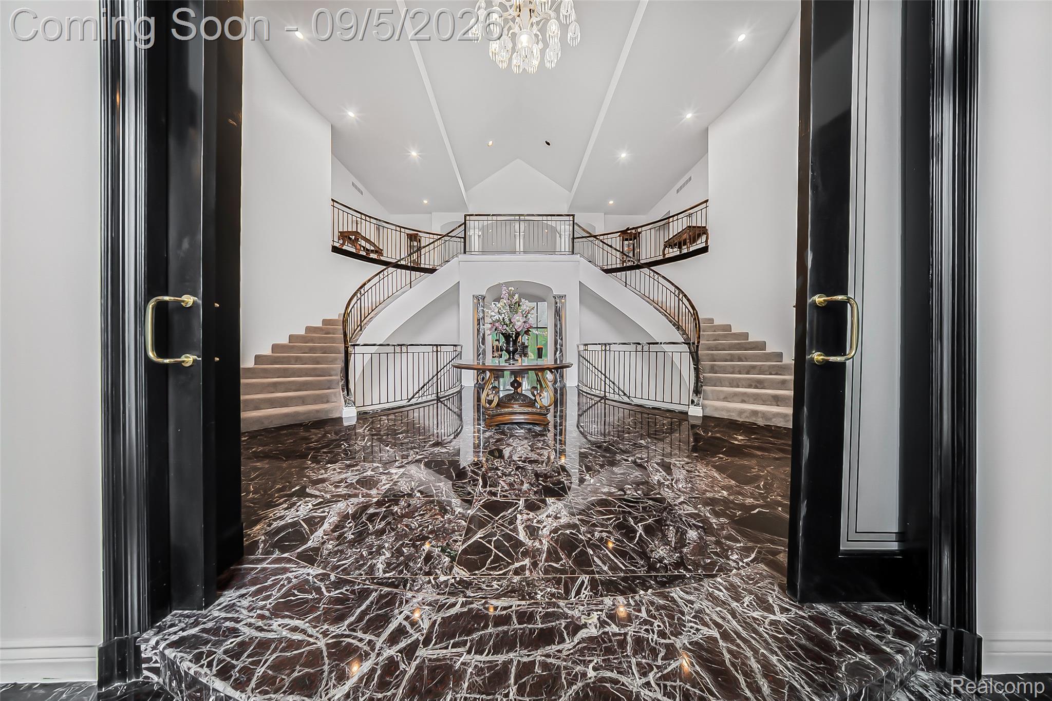 2785 Cranbrook Ridge Court Rochester, MI 48306 - Photo 15 of 97 Grand entryway featuring a double staircase with wrought iron railings, vaulted ceiling, recessed lighting, and a prominent crystal chandelier