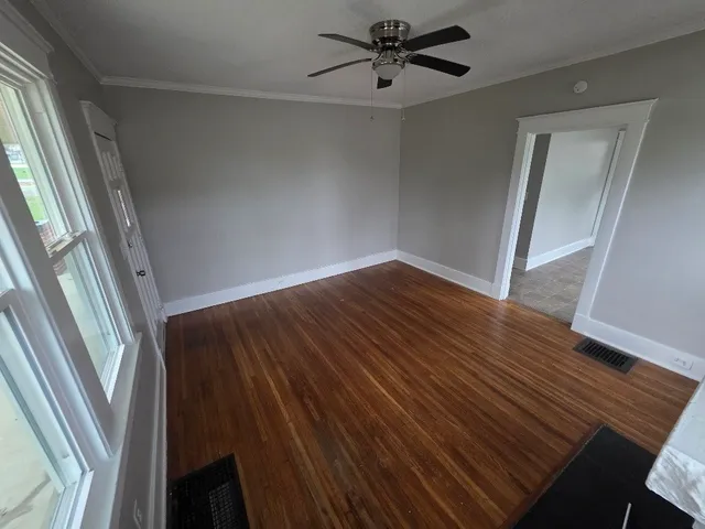 a view of empty room with wooden floor
