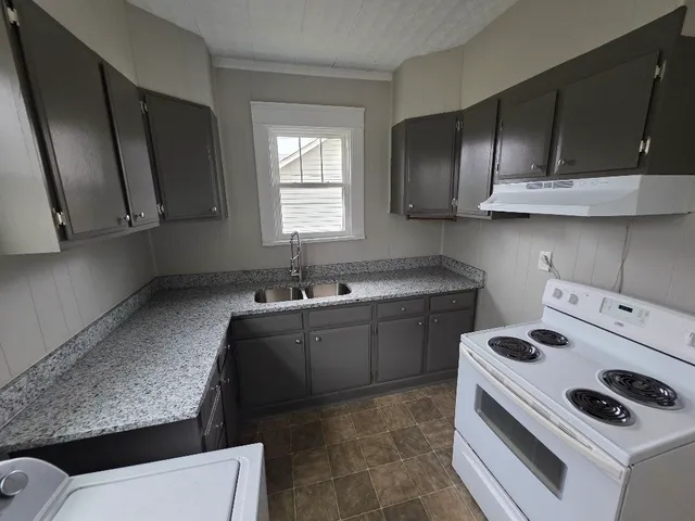 a kitchen with a sink a stove and cabinets