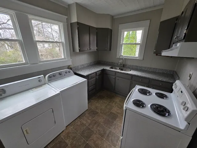 a kitchen with a sink a stove and cabinets