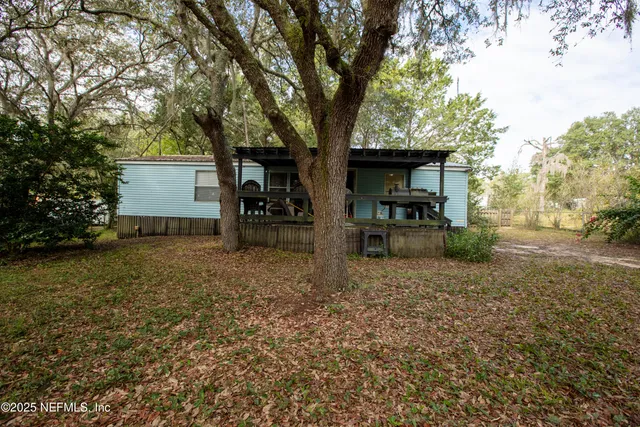a backyard of a house with barbeque oven table and chairs