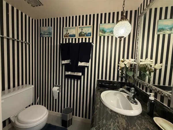 a bathroom with a sink a toilet and mirror