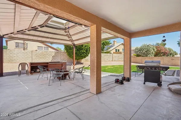 a view of a patio with a table and chairs and a barbeque