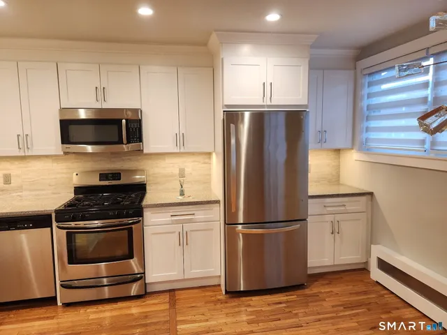 a kitchen with wooden cabinets and stainless steel appliances