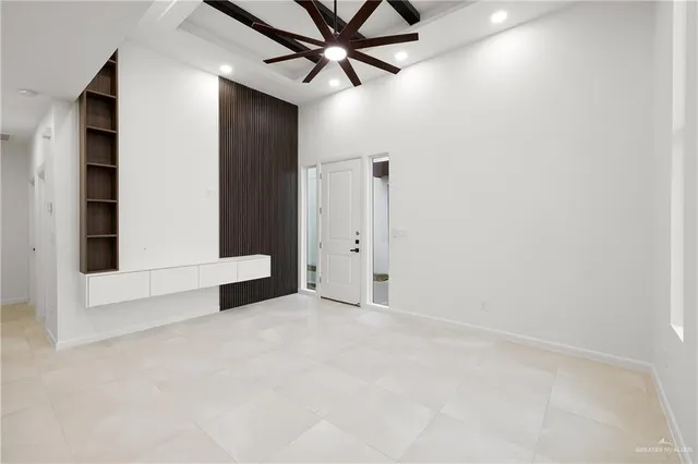 an empty room with chandelier fan